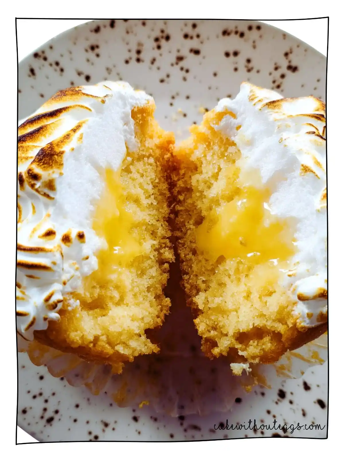 Inside View of Eggless Lemon Meringue Cupcake Showing Lemon Curd Center and Toasted Meringue Eggless Lemon Meringue Cupcake cut open showing lemon curd filling