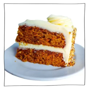 Thick slice of egg-free carrot cake with creamy frosting and nutty edges on a white dessert plate