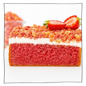 Eggless Strawberry Crunch Cake slice with white frosting and crunchy strawberry topping, served on a white background.